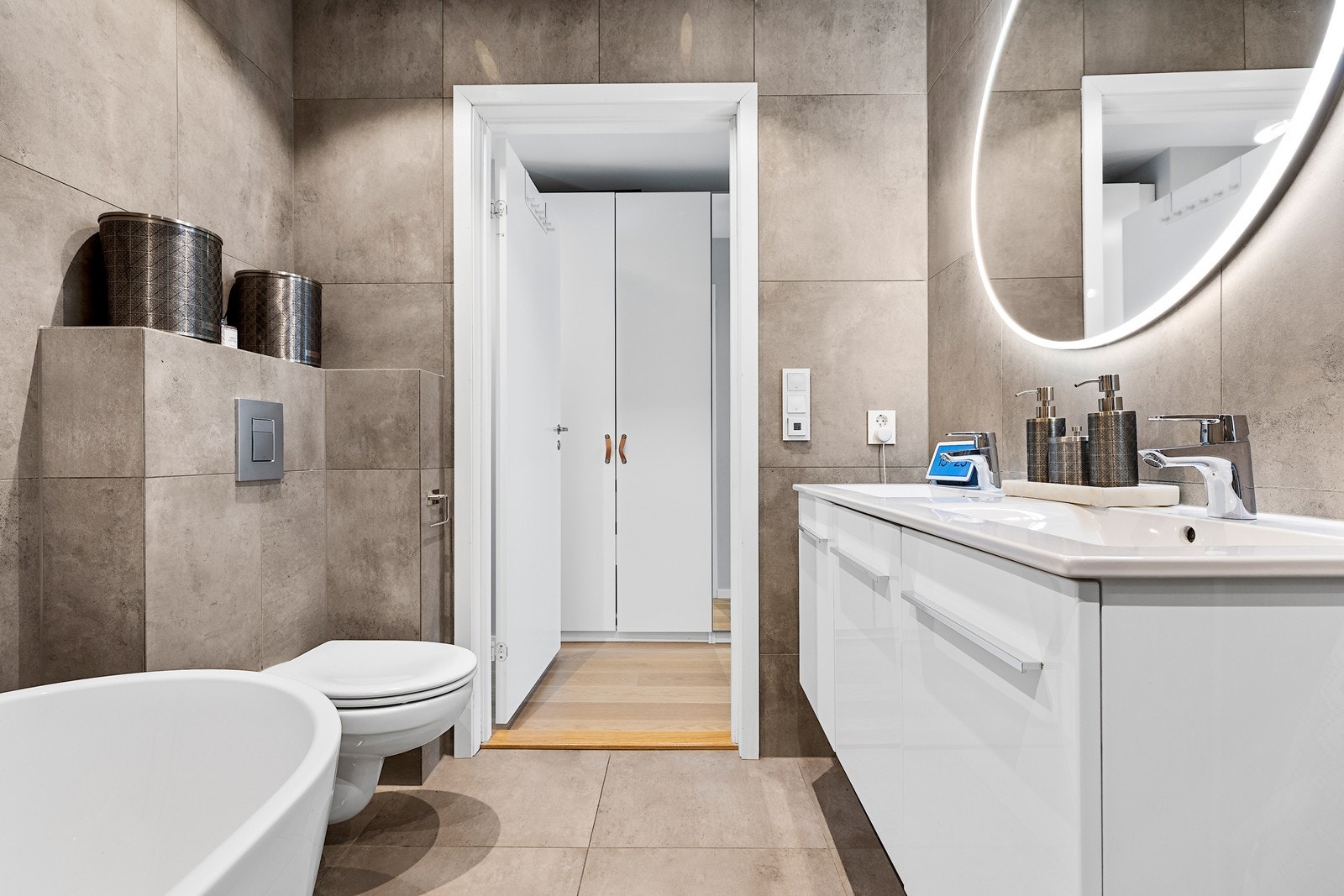 ommet er innredet med frittstående badekar, romslig dusjsone med glassdører og en elegant baderomsinnredning med dobbel servant. Galleribilde