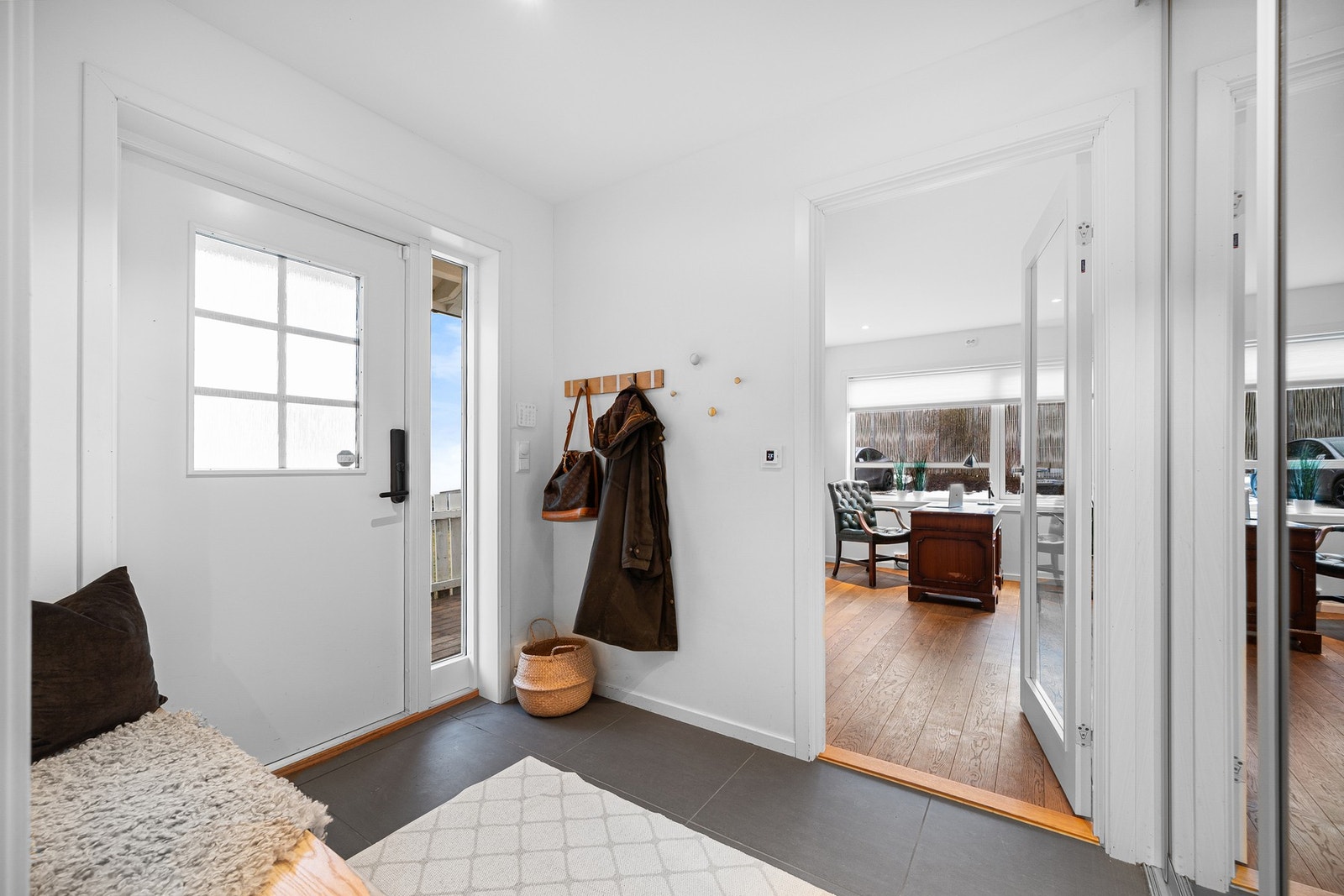 Lys og romslig hall med skyvedørsgarderobe. Flislagt, slitesterkt gulv med gulvvarme. Galleribilde