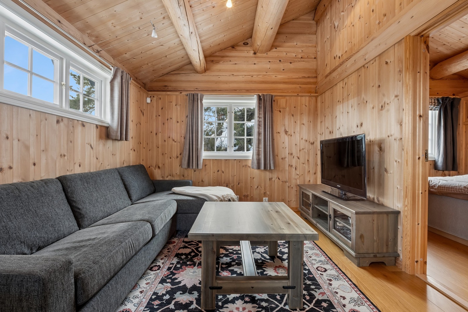 holder samme høye tekniske standard som hytta, og innehar gang med skifergulv, kjøkken og stue i åpen løsning samt soverom med tilliggende bad. Galleribilde