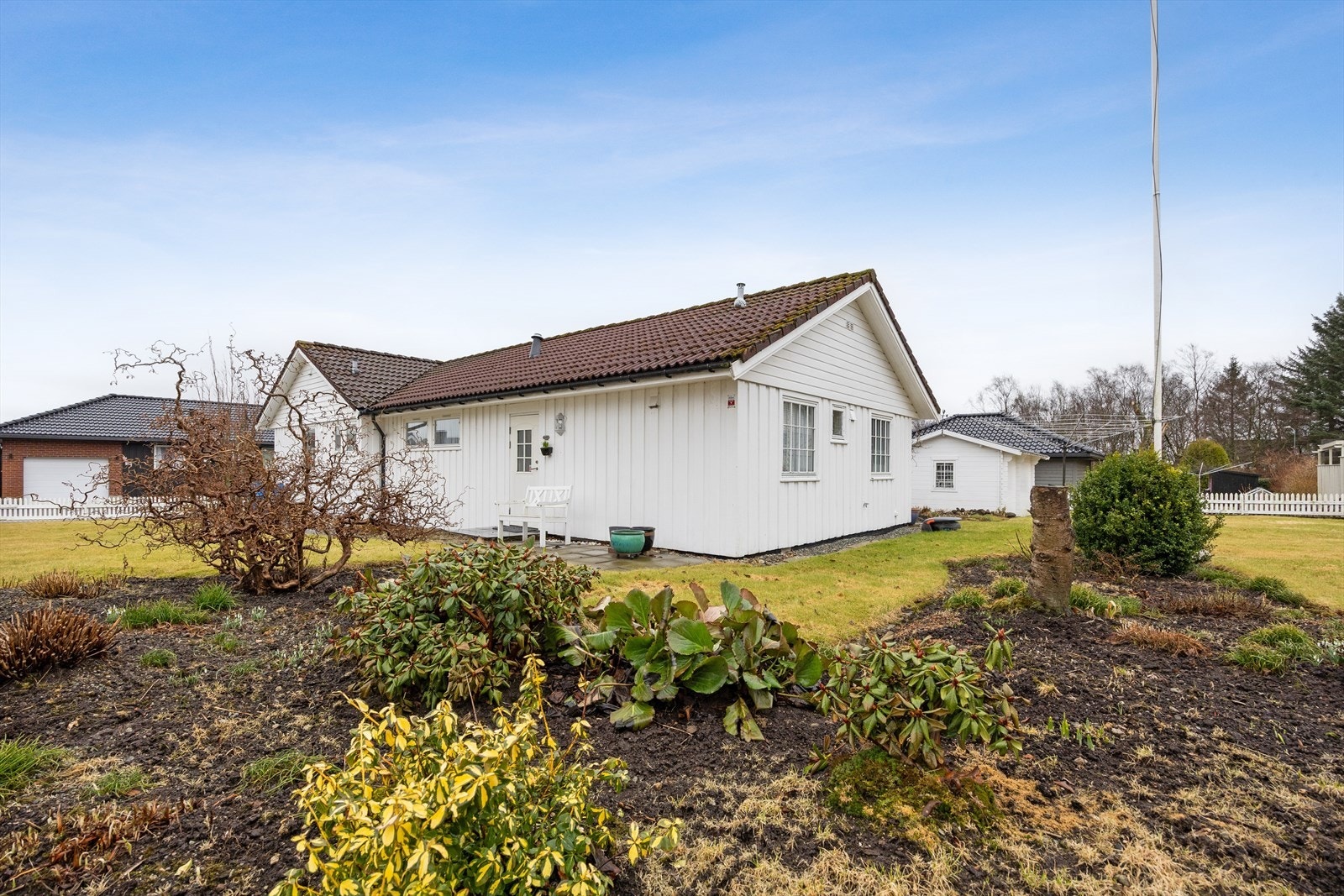 Tomten er tilnærmet flat og pent opparbeidet med en stor hage som ligger sør-vest vendt med gode solforhold. Hagen er pent opparbeidet med blomsterbed som er beplantet med ulike vekster og trær. Galleribilde