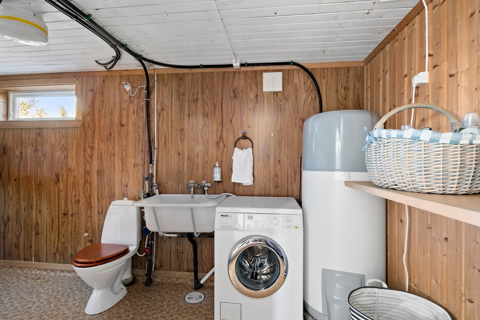 Vaskerommet har vinylbelegg på gulv og praktisk vaskekar. Galleribilde