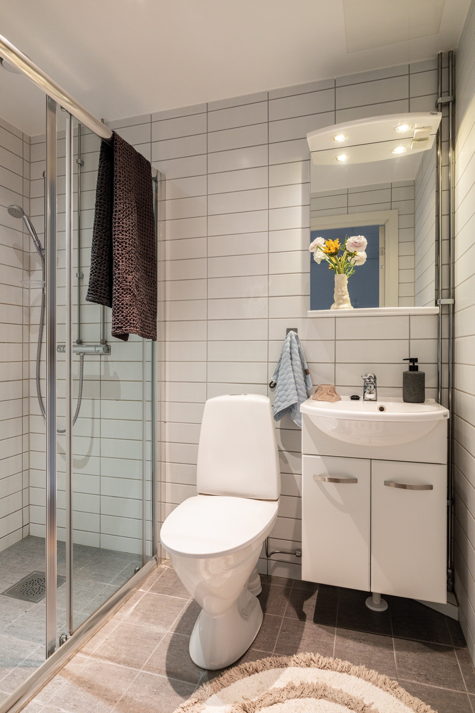 Videre er det dusjhjørne med skyvedører i glass samt toalett. Himlingen er utstyrt med downlights som gir god belysning i rommet. Galleribilde