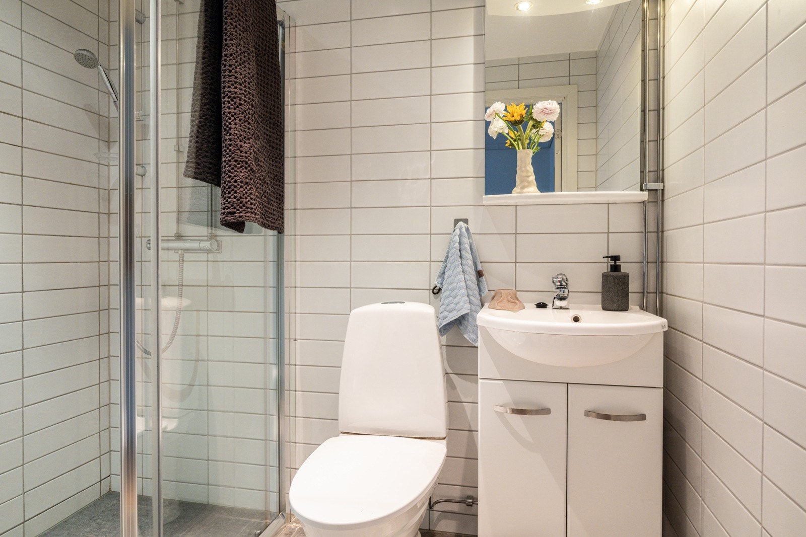 Flislagt bad/wc med elektriske varmekabler i gulv og mekanisk avtrekk. Badet er innredet med servant med tilhørende baderomsinnredning, speil og praktisk spotthylle. Galleribilde