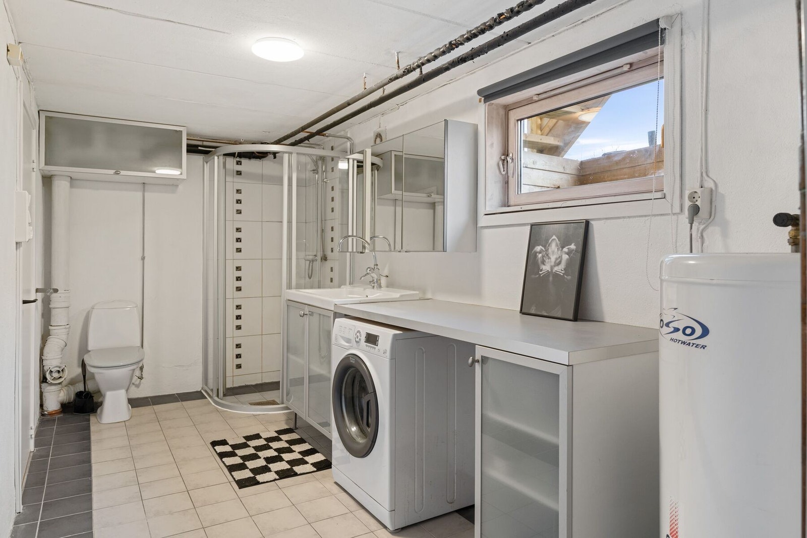 Stort bad på hele 10,5 m² utstyrt med toalett, dusjhjørne, innredning med servant og opplegg for vaskemaskin. Galleribilde