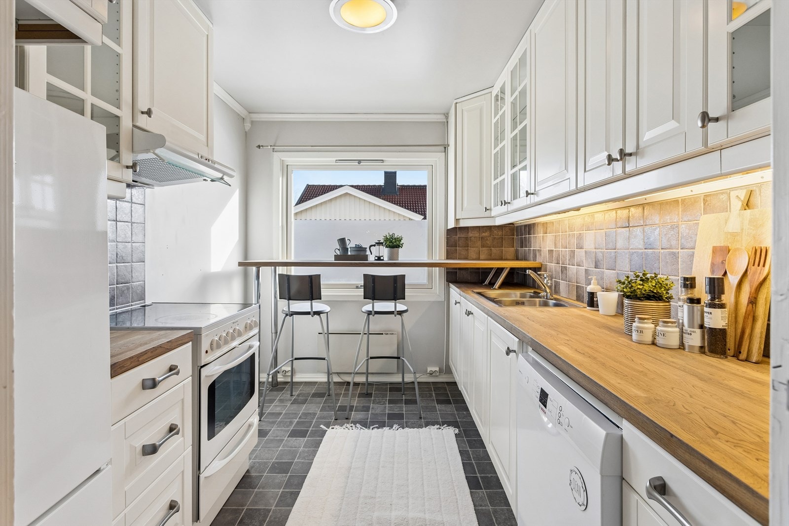 Kjøkkenet har en praktisk barløsning ved vinduet og godt med skap- og benkeplass. Galleribilde