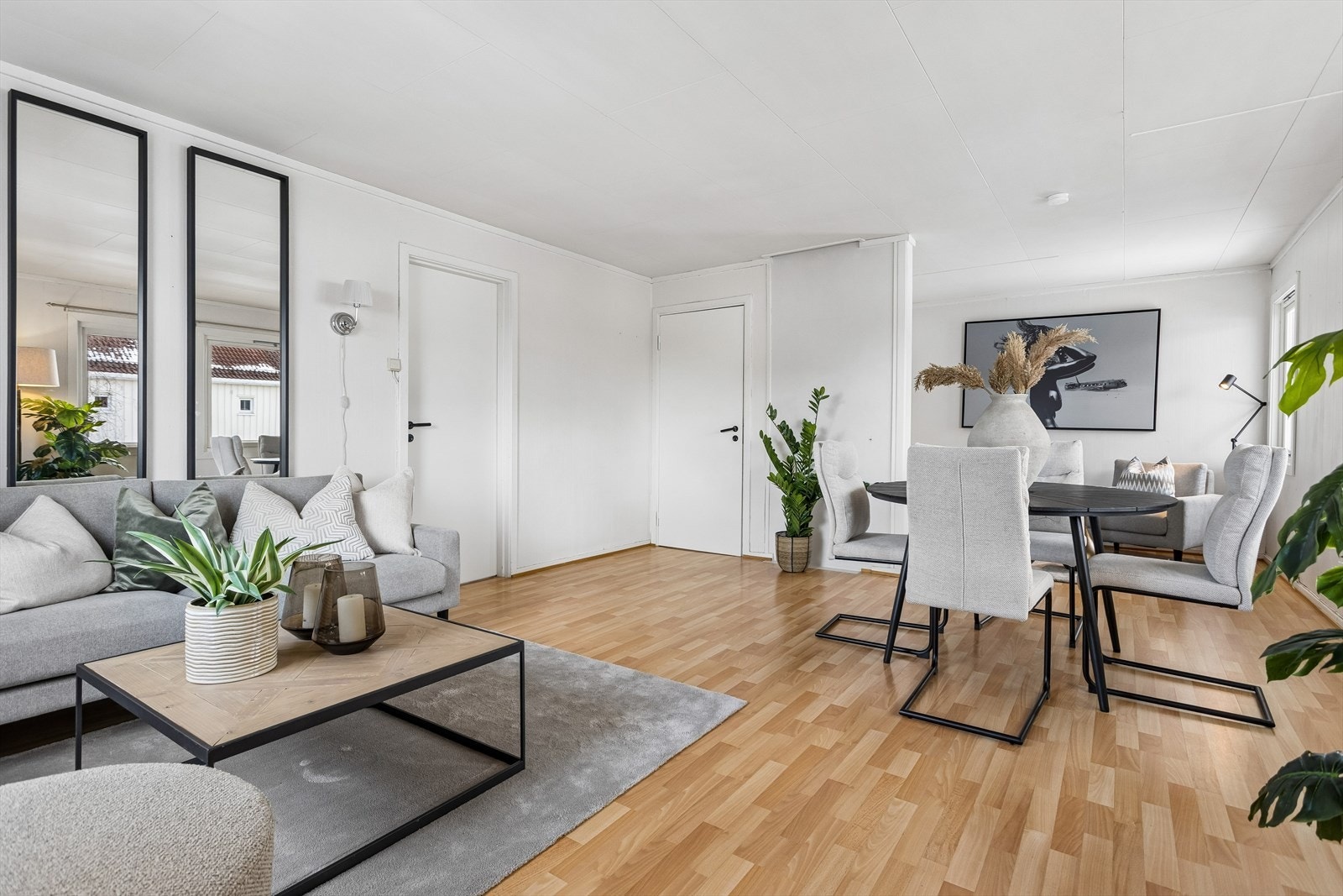 Gjennomgående laminatgulv og lyse veggflater skaper en helhetlig atmosfære i oppholdsrommene. Galleribilde