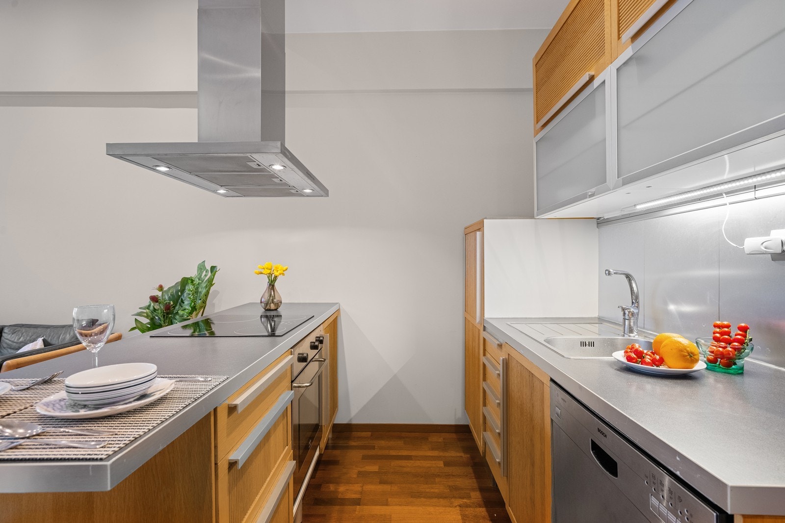 Flott kjøkkeninnredning med integrert koketopp, stekeovn og kjøleskap, samt frittstående oppvaskmaskin. Galleribilde