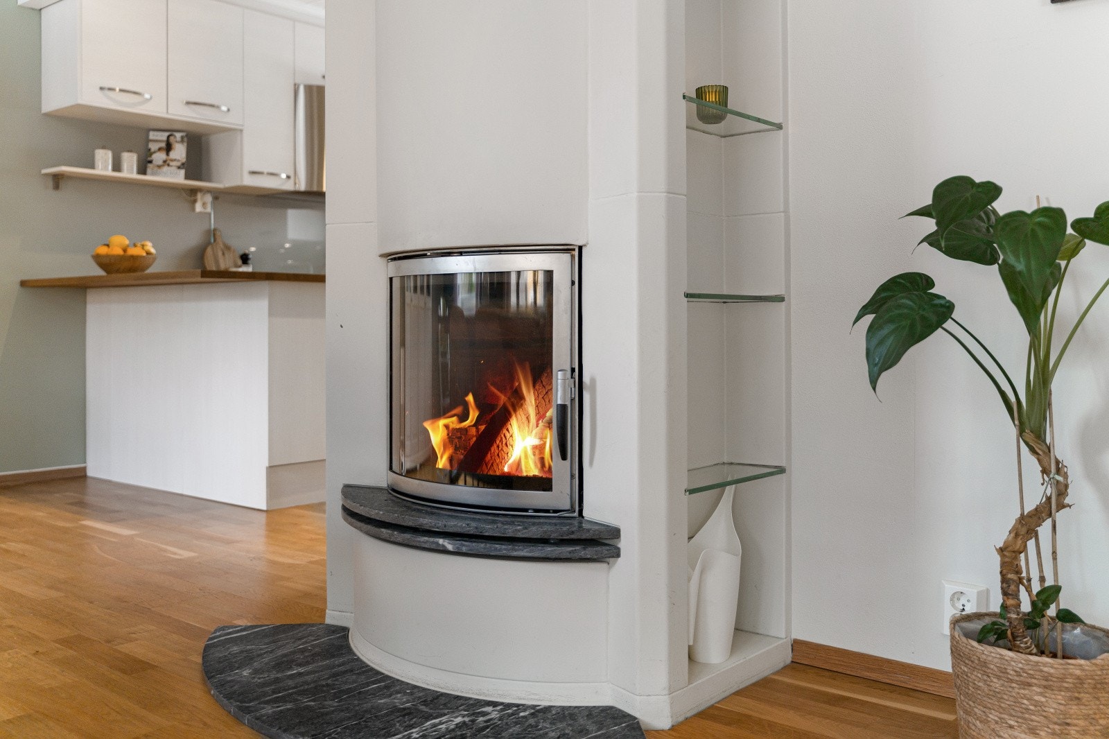 Moderne peisinnsats i veggen med hylle integrert på siden. Galleribilde