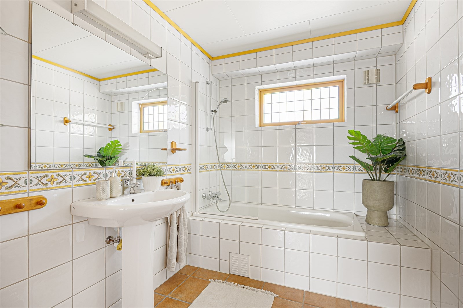 Badet er innredet med innbygget badekar, søylevask og toalett. Det er elektrisk styrt vifte på vegg. Galleribilde