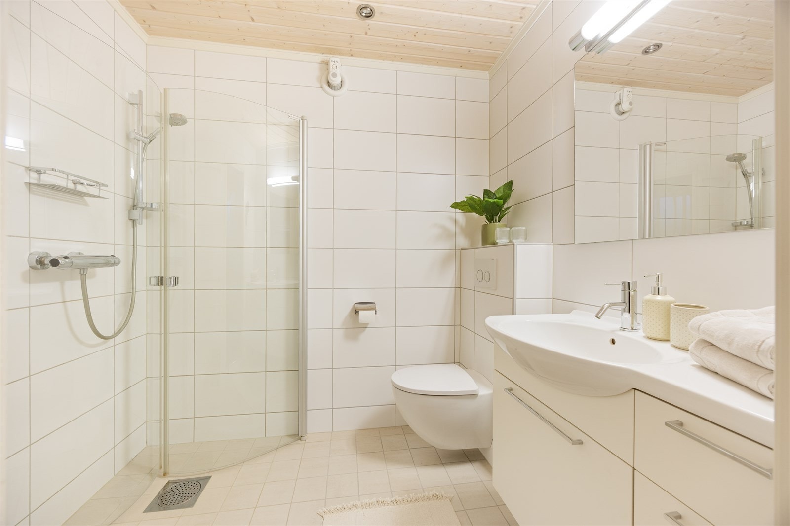 Flislagt bad med varmekabler i gulv og spotter i tak. Galleribilde