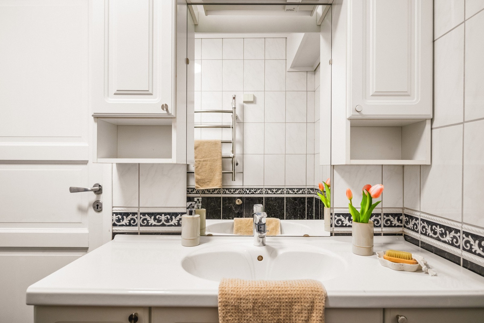 Badet inneholder helstøpt servant, skap under servant med profilerte fronter og badekar. Galleribilde