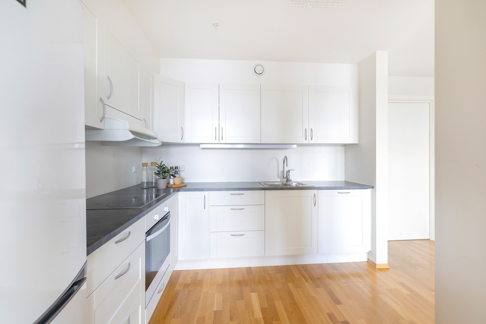 Kjøkken med hvite fronter og laminat benkeplate. Galleribilde