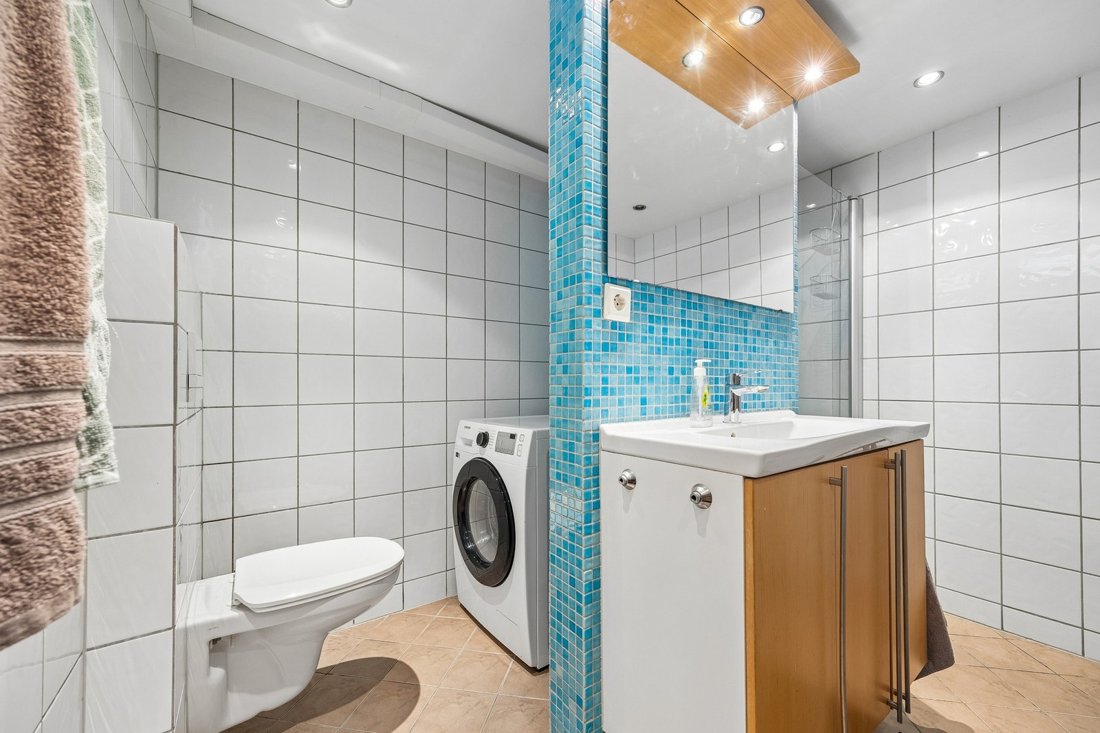 Badet har plass til vaskemaskin og oppbevaring. Galleribilde