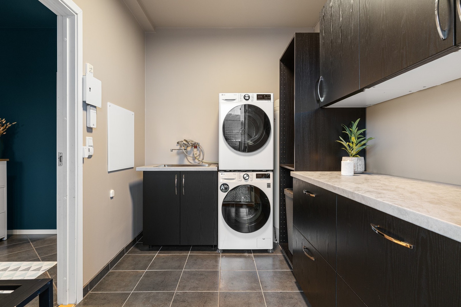 Vaskerommet er en funksjonell og romslig plass som gjør hverdagslige gjøremål lettere og mer effektive. Her finner du god benkeplass til sortering og folding av klær, samt praktisk oppbevaringsplass for vaskemidler og annet utstyr. God plass til både vask Galleribilde