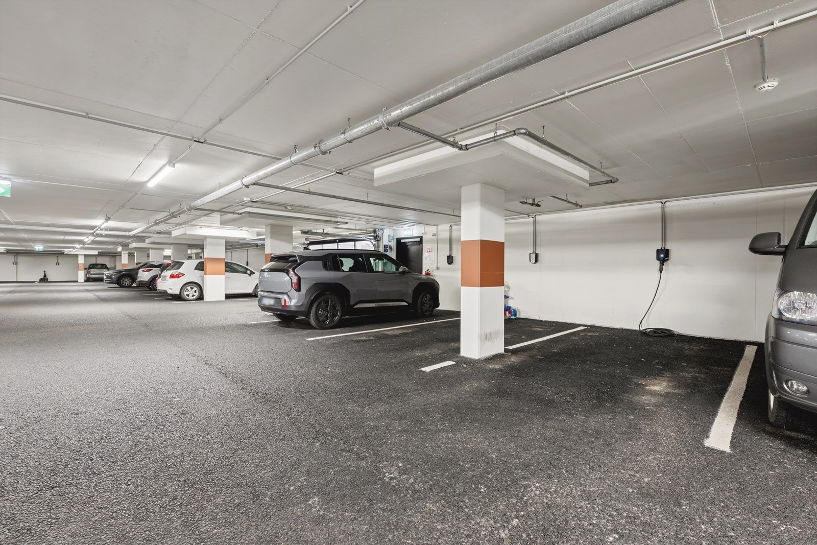 Oppmerket parkeringsplass i lukket anlegg med elbil lading Galleribilde