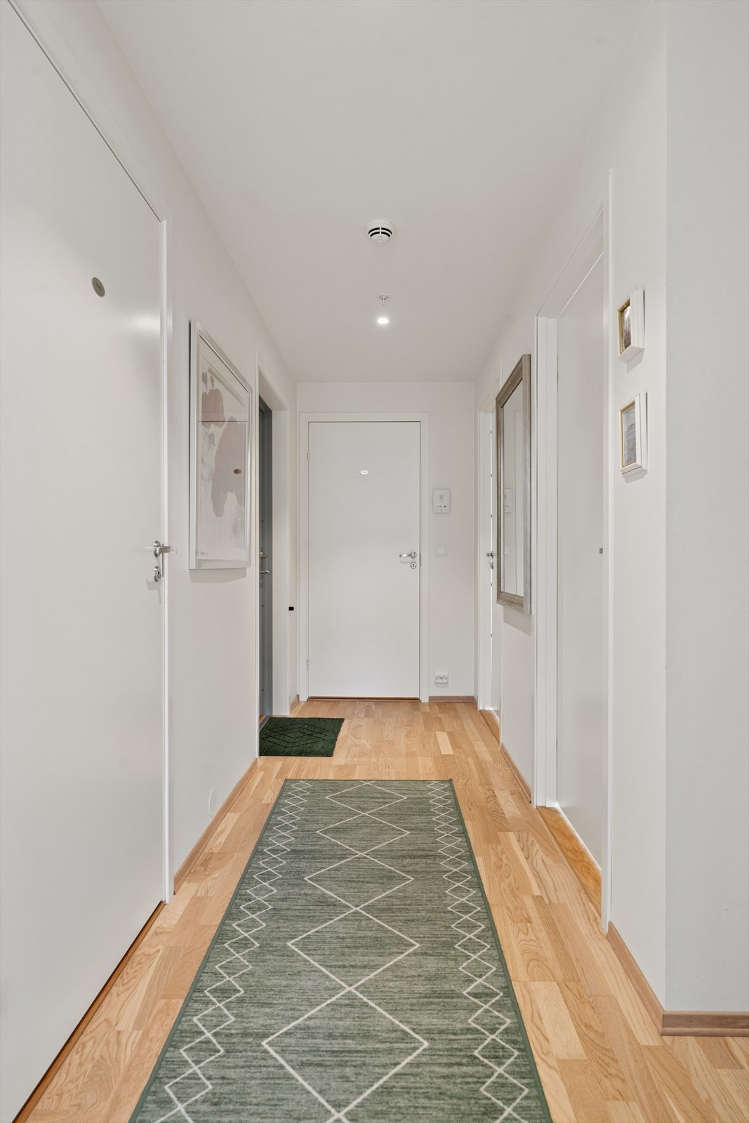 Gang med adkomst til gjestetoalett, soverom 1, soverom 2, bad, åpen stue- og kjøkken løsning Galleribilde