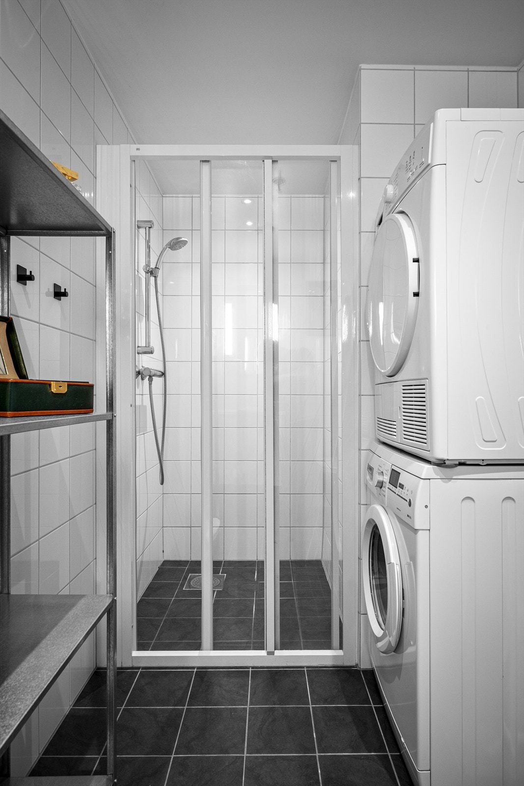 Helfliset bad med vegghengt wc, dusjhjørne og varme i gulv for ekstra komfort. Badet fremstår som arealeffektivt med pen baderomsinnredning. Opplegg for vaskemaskin og tørketrommel kan også nevnes. Galleribilde