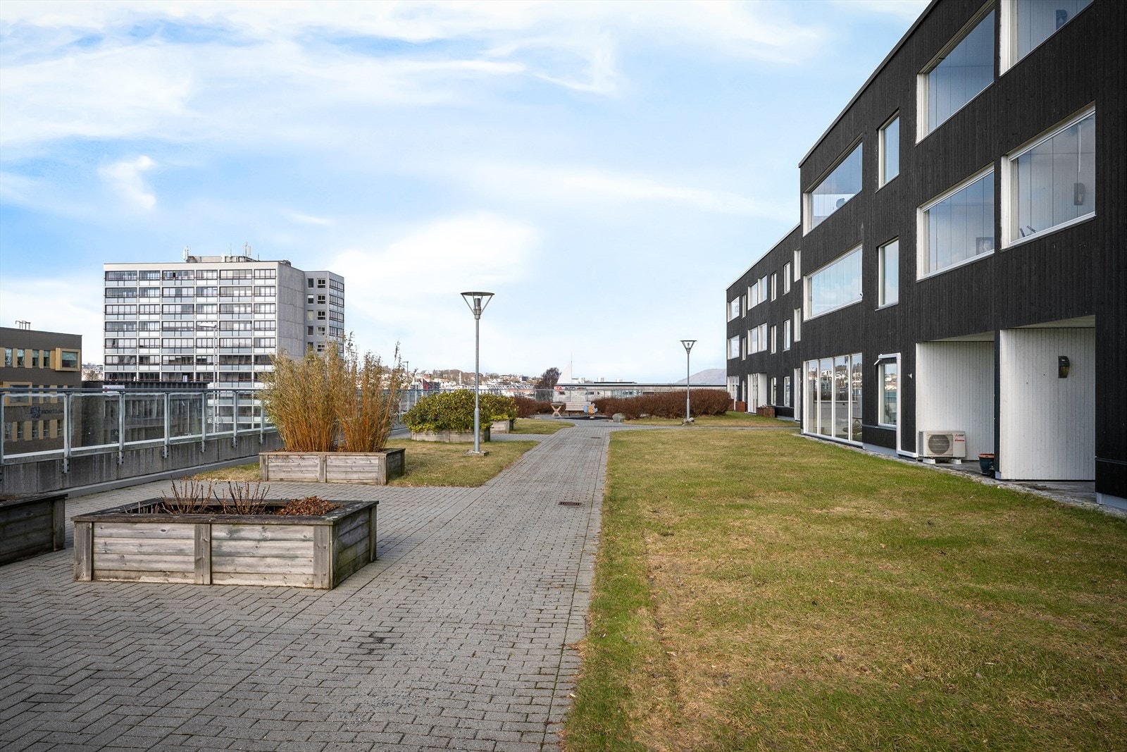 Felles tomt for sameiet er pent opparbeidet og inkluderer velstelte grøntområder, lekeplass og flere andre fasiliteter. Galleribilde