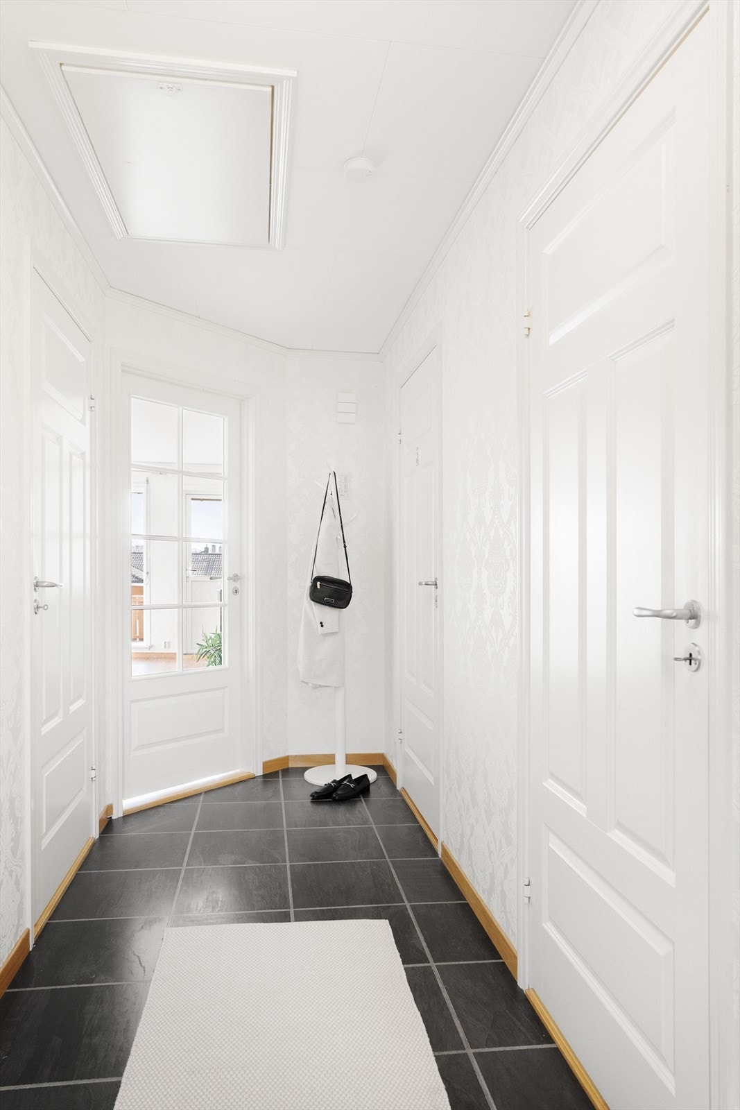 Pent flislagt gulv entré med god plass til å henge fra seg yttertøy Galleribilde