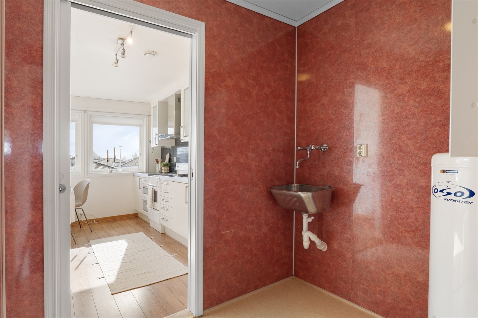 Praktisk og separat vaskerom med skyvedør til kjøkken og bad. Galleribilde