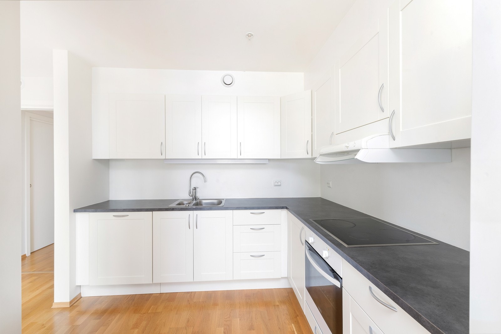 Kjøkken med hvite fronter og laminat benkeplate. Galleribilde