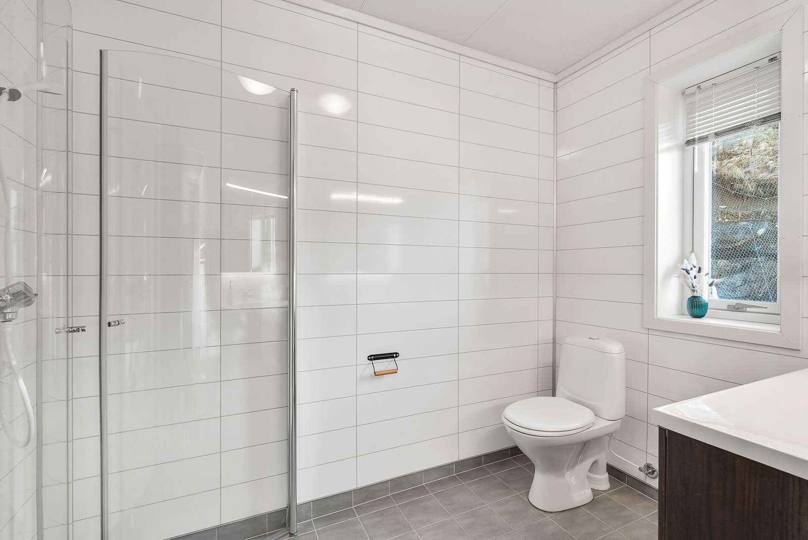 Pent og tidløst bad i 3. etg med flislagt gulv og våtromsplater på vegg. Varmekabler i gulv. Galleribilde