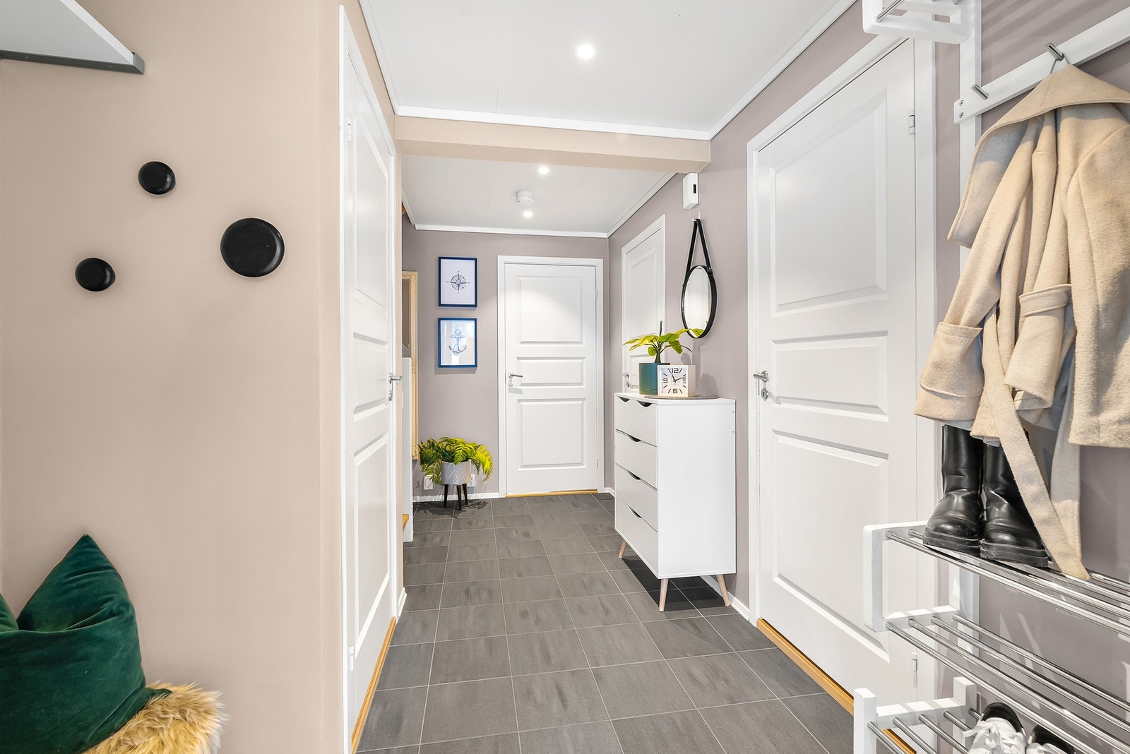 Innbydende entré med flislagt gulv med varmekabler og downlights i himling. Åpen garderobeløsning. Galleribilde