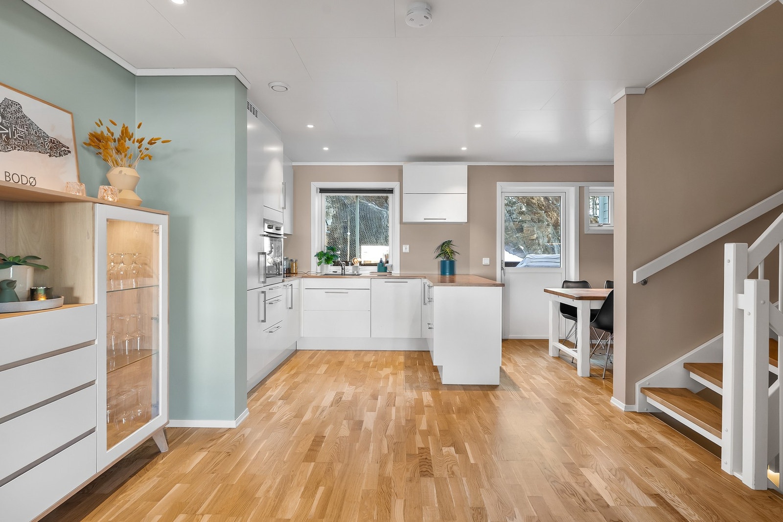 Stue/kjøkken i åpen løsning. Gjennomgående lysinnslipp fra store vindusflater på begge sider av stua. Galleribilde