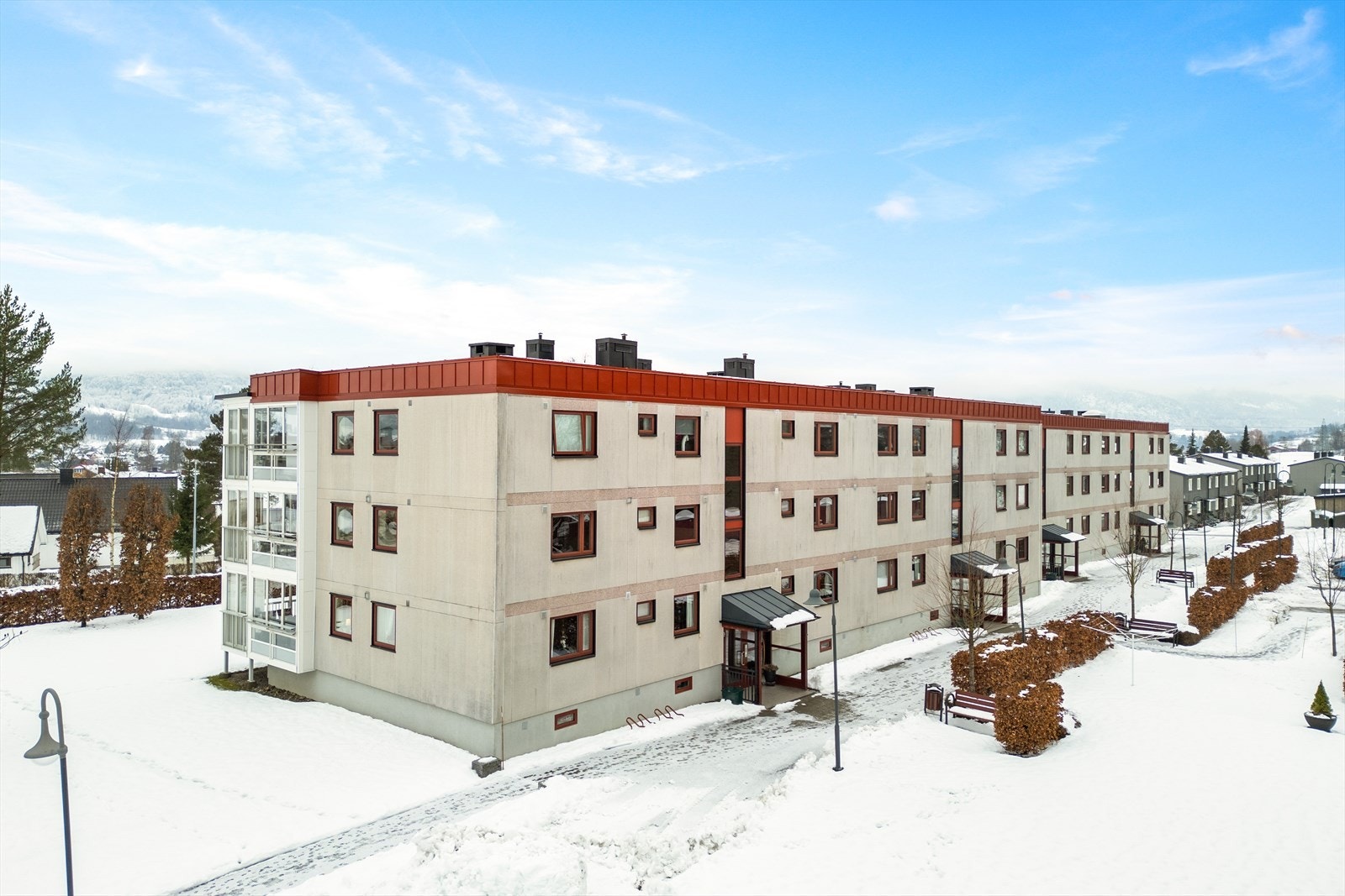 Pent opparbeidet felles tomt for borettslaget med grøntarealer, prydbusker og asfaltert adkomstvei og parkeringsplasser. Lekeplass i borettslaget. Galleribilde