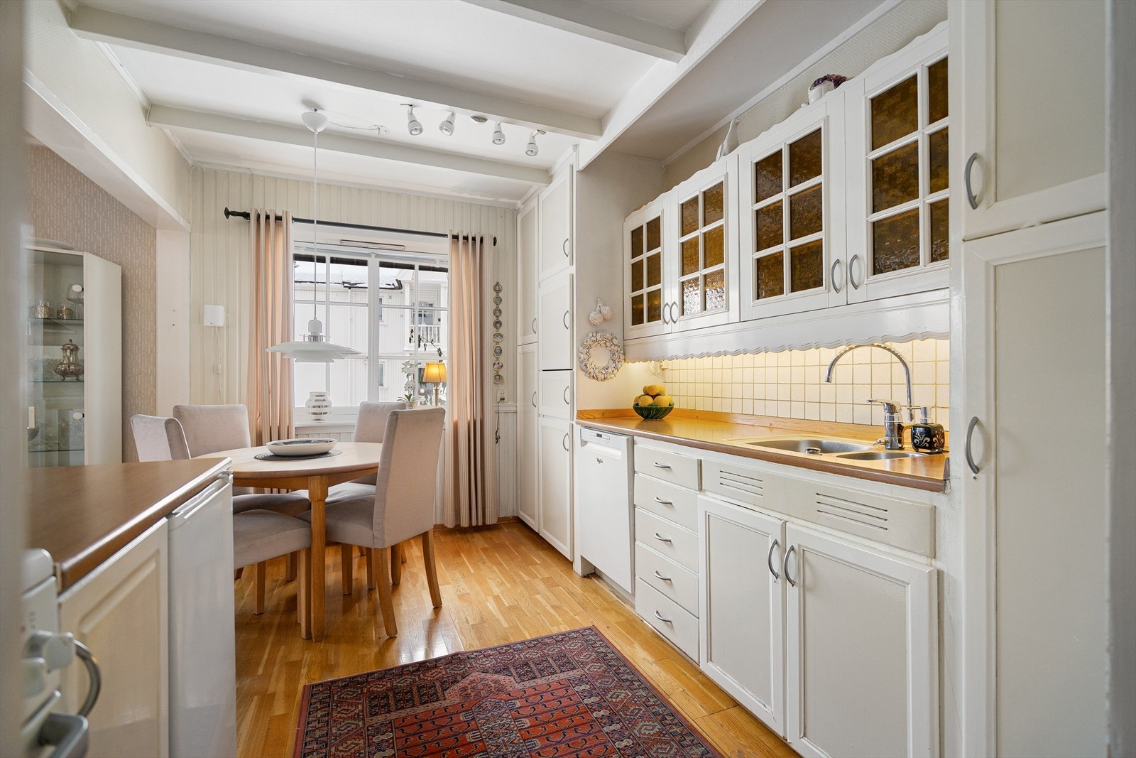 Lys kjøkkenløsning som har godt med skapplass og benkeareal Galleribilde