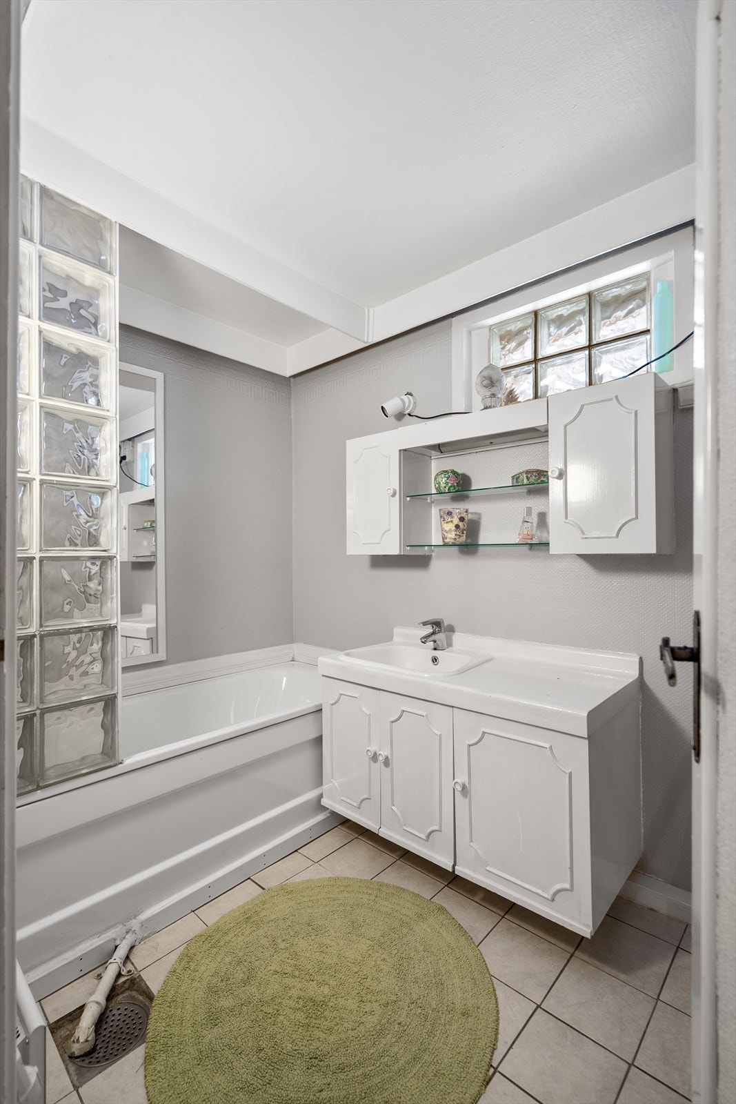 Bad i kjelleretasje inneholder badekar, servant med underskap og overskap, toalett samt dusjkabinett Galleribilde