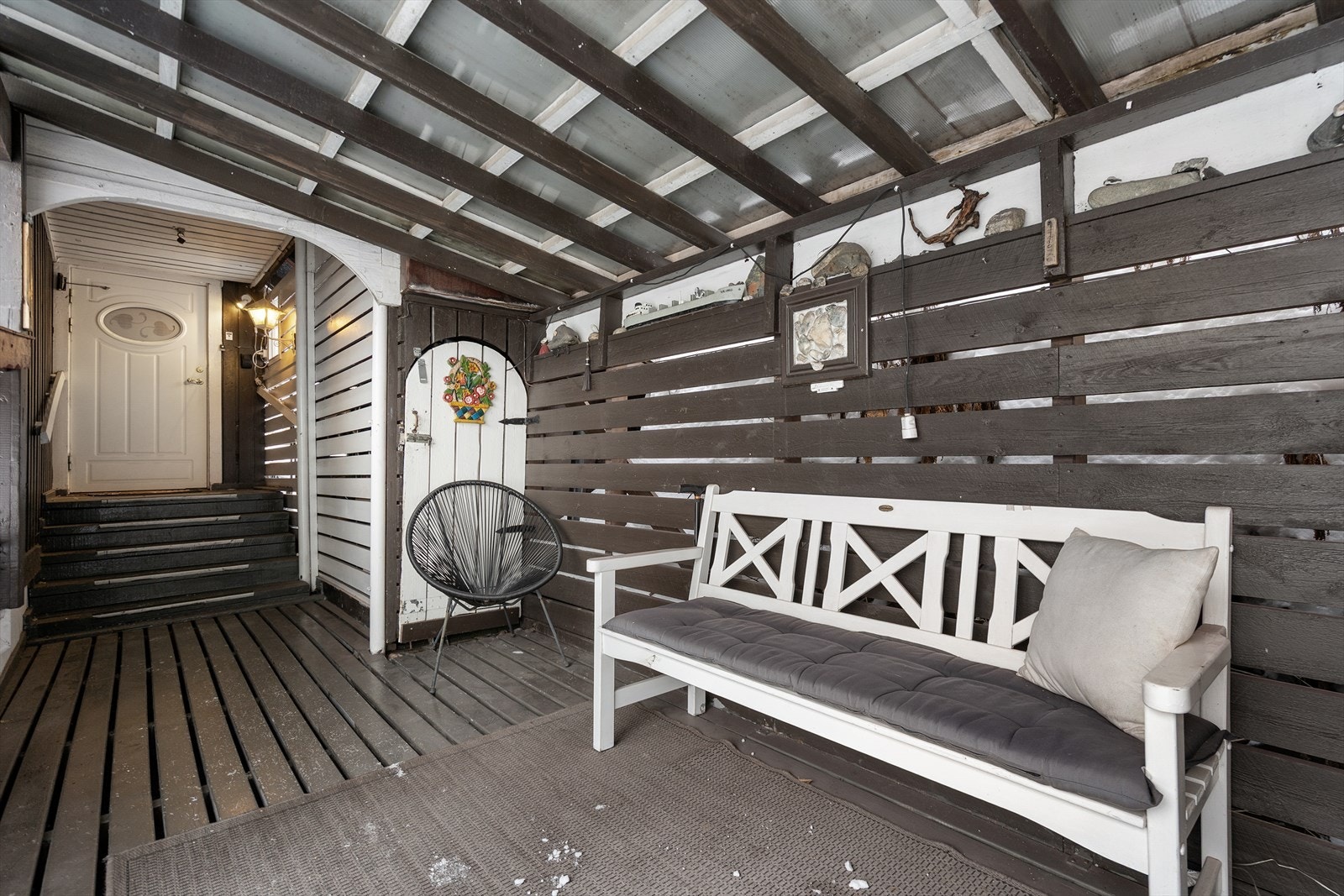 Overbygget inngangsparti og uteplass som gir ly for vær og vind Galleribilde