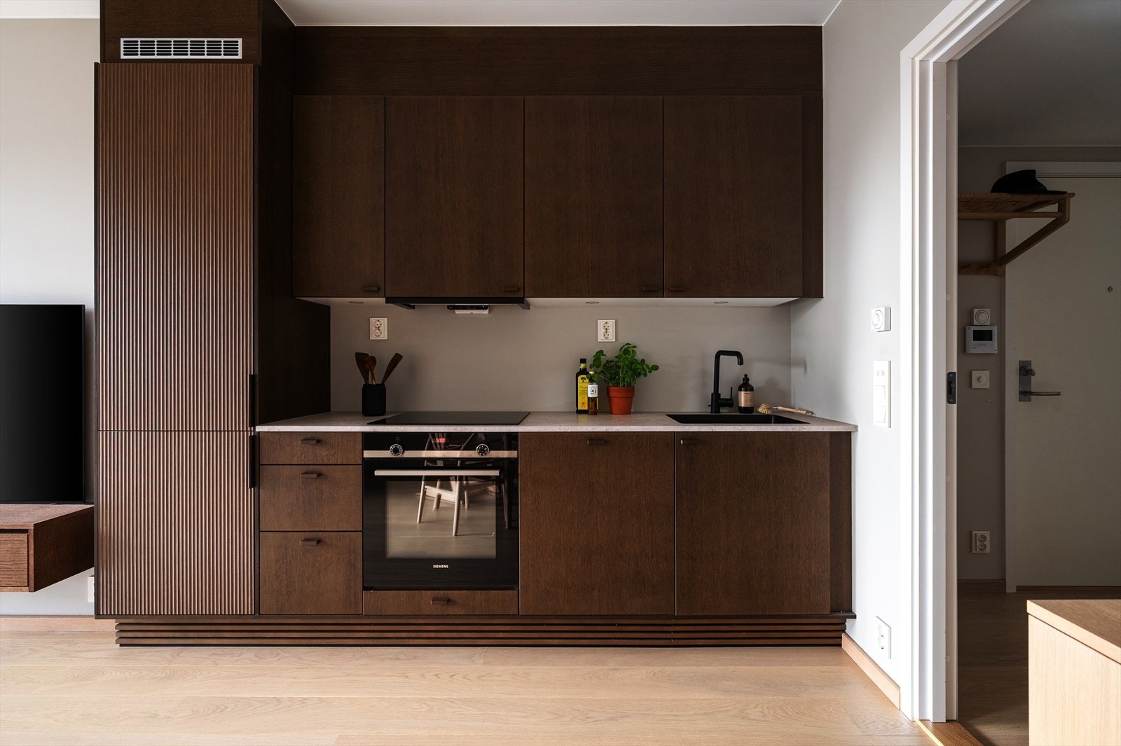 Moderne kjøkkeninnredning med mørk brune, glatte fronter og laminat benkeplate Galleribilde