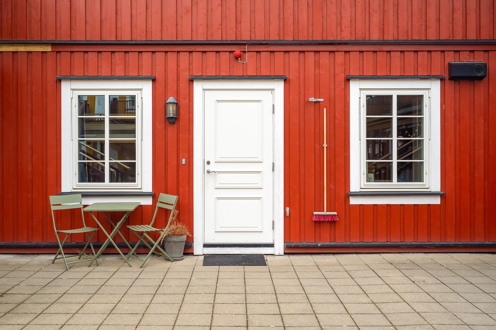 Utenfor inngangsdør på bakkeplan er det lagt praktiske steinheller. Fint for å ha utemøbler mot skjermet fellesareal. Galleribilde