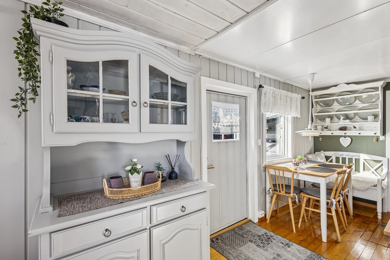 En koselig krok for måltider, med overflater i malt panel og tregulv. Galleribilde