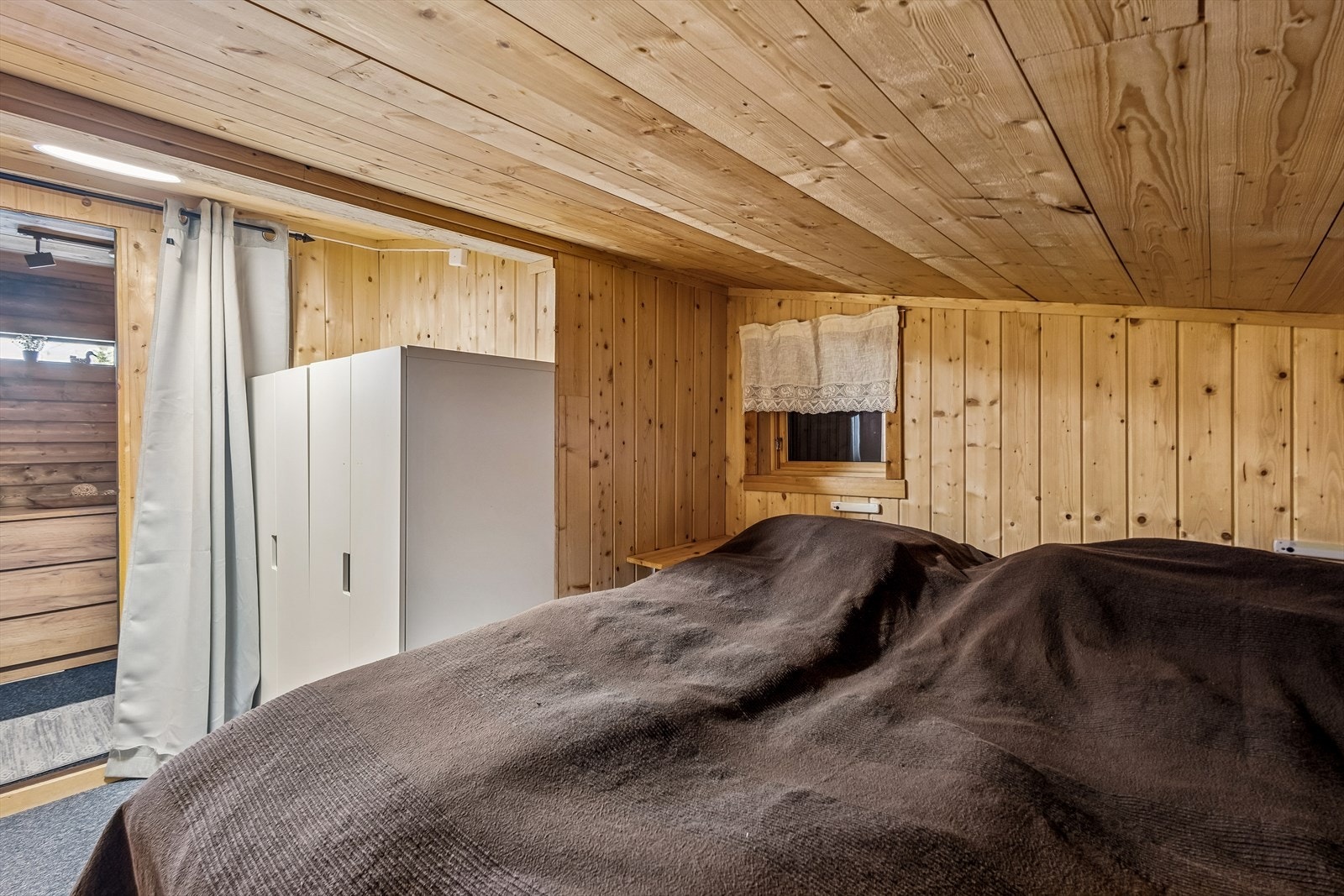 I den ombygde delen av hytta, en tidligere garasje, finnes en praktisk sovealkove. Galleribilde