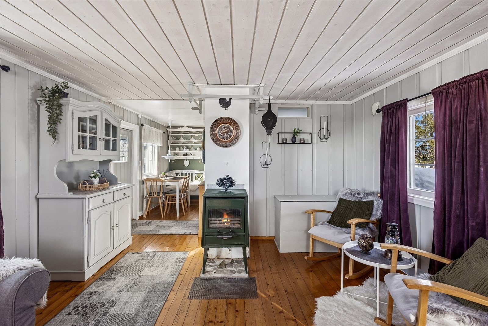 Stuen samles rundt en eldre peisovn som gir både varme og atmosfære. Galleribilde