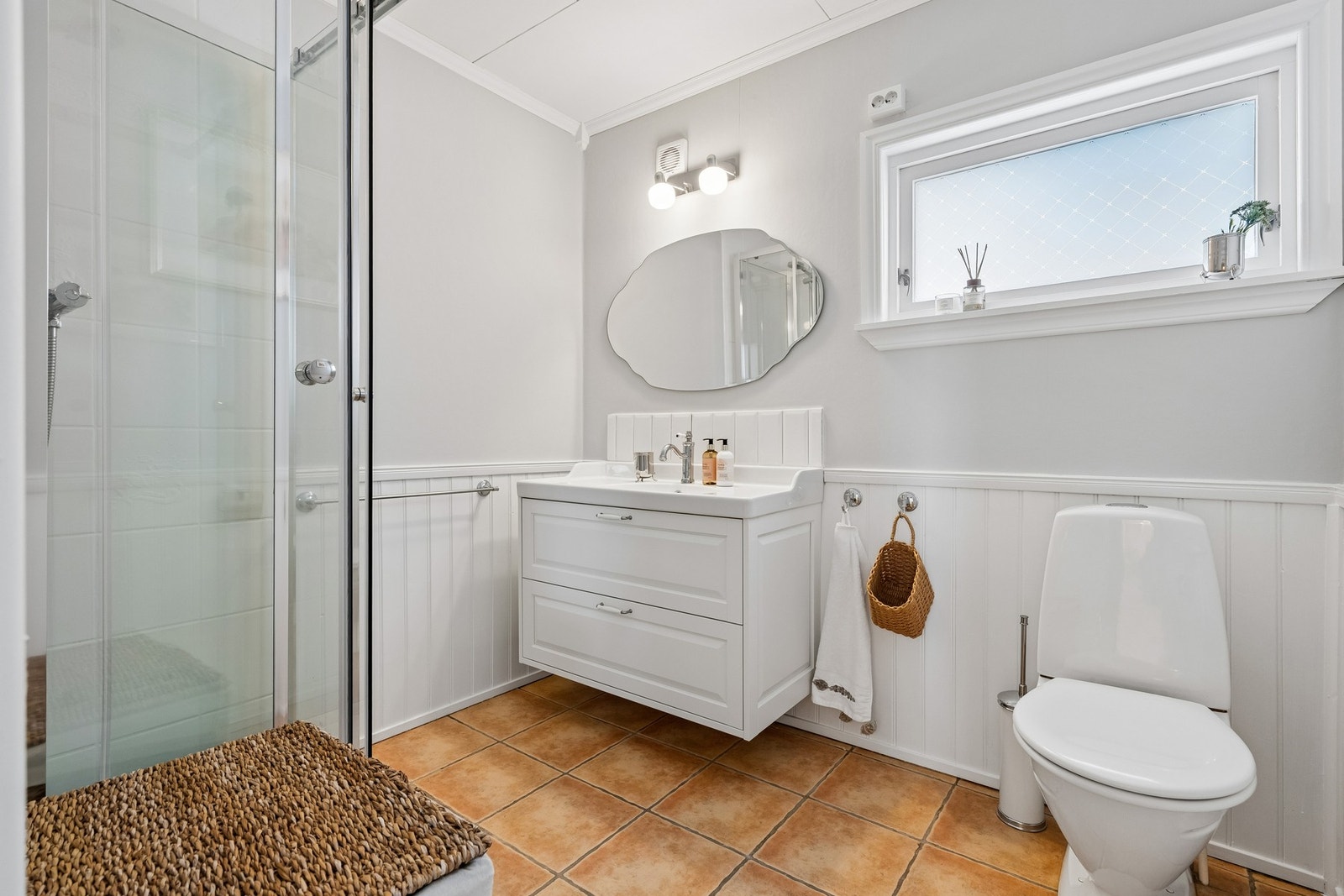 Bad i første etasje med dusj, toalett og vegghengt servant Galleribilde