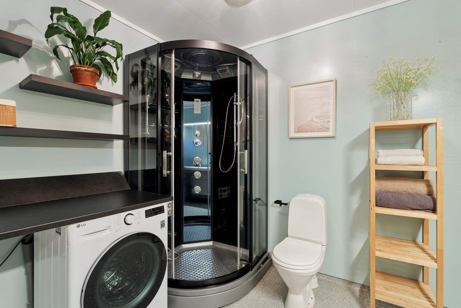 Badet er utstyrt med dusj, toalett og en moderne innredning med servant og speil. Galleribilde