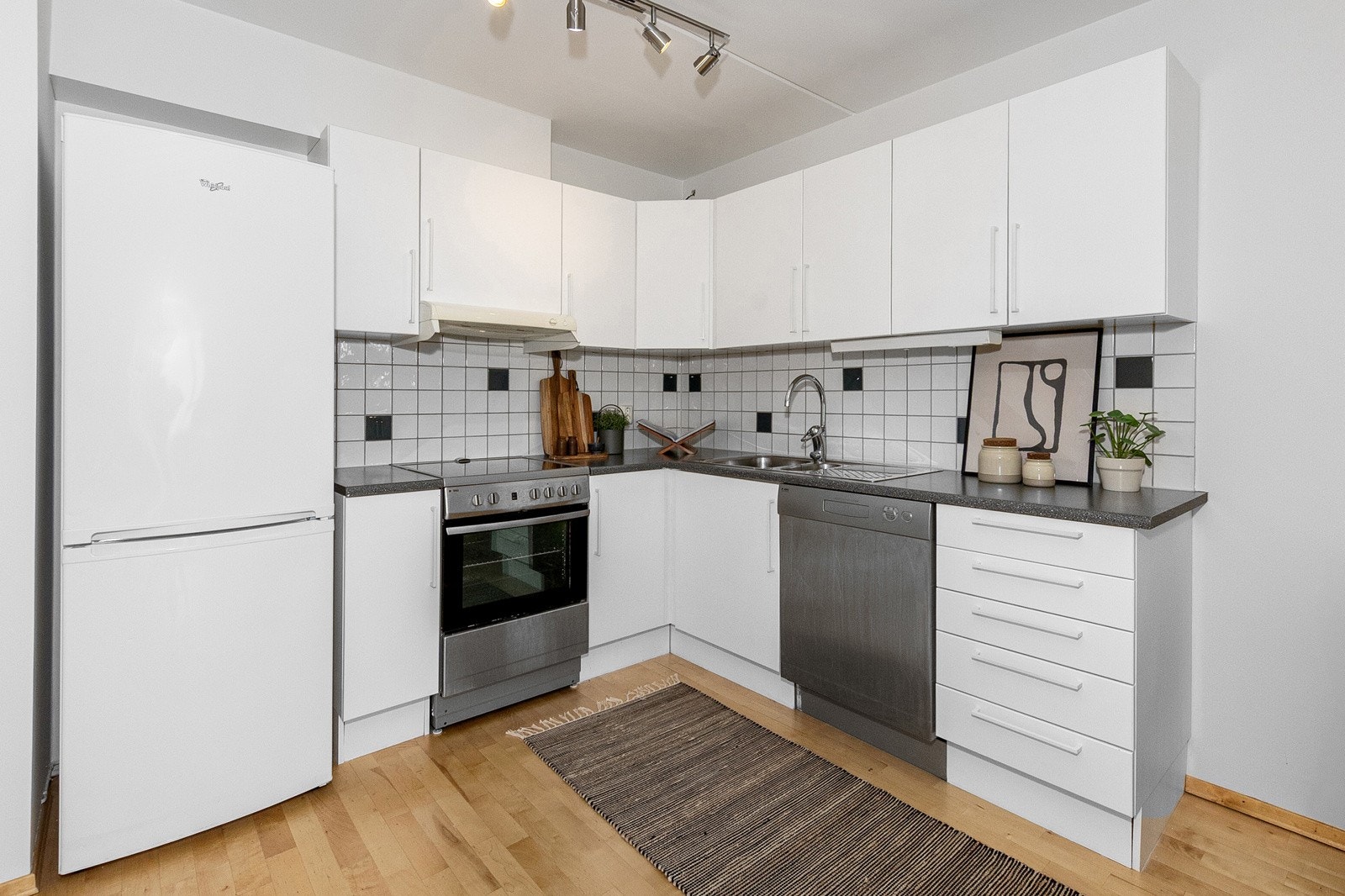 Kjøkkenet fra byggeår er pent og funksjonelt, med slette fronter, laminert benkeplate og fliser over benk. Galleribilde