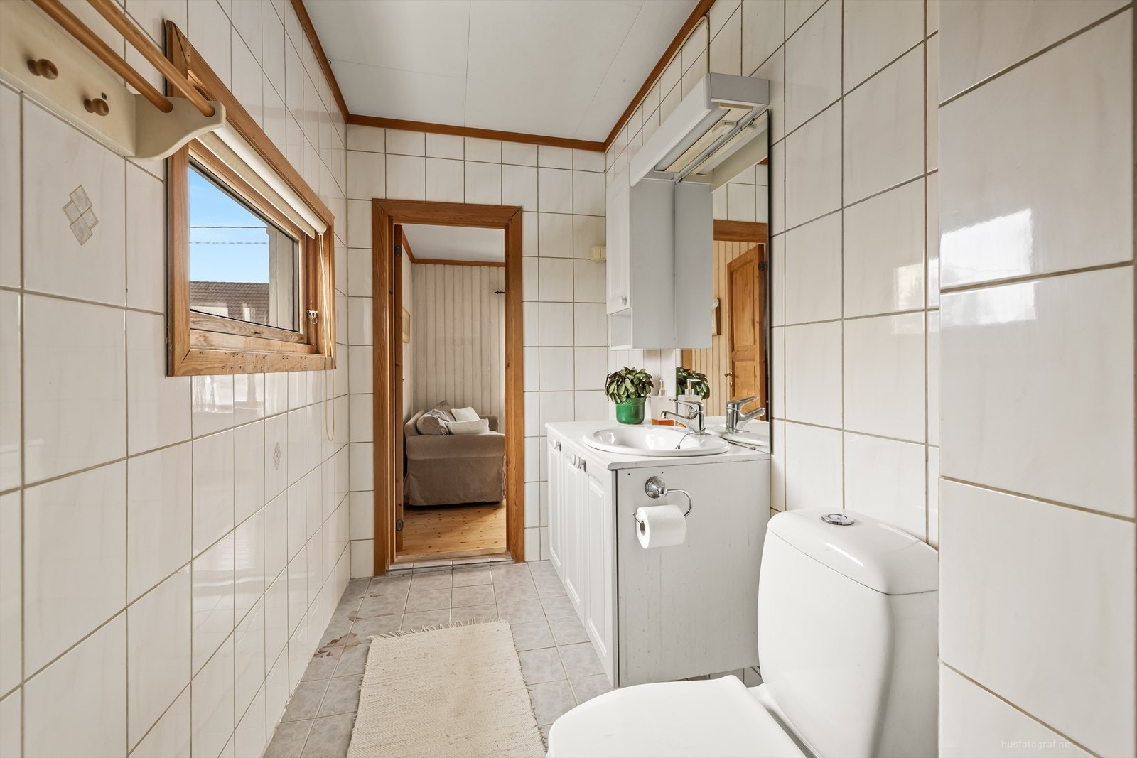 Sanitærutstyr med klosett, dusjnisje med forheng, servant montert i innredning og opplegg for vaskemaskin Galleribilde