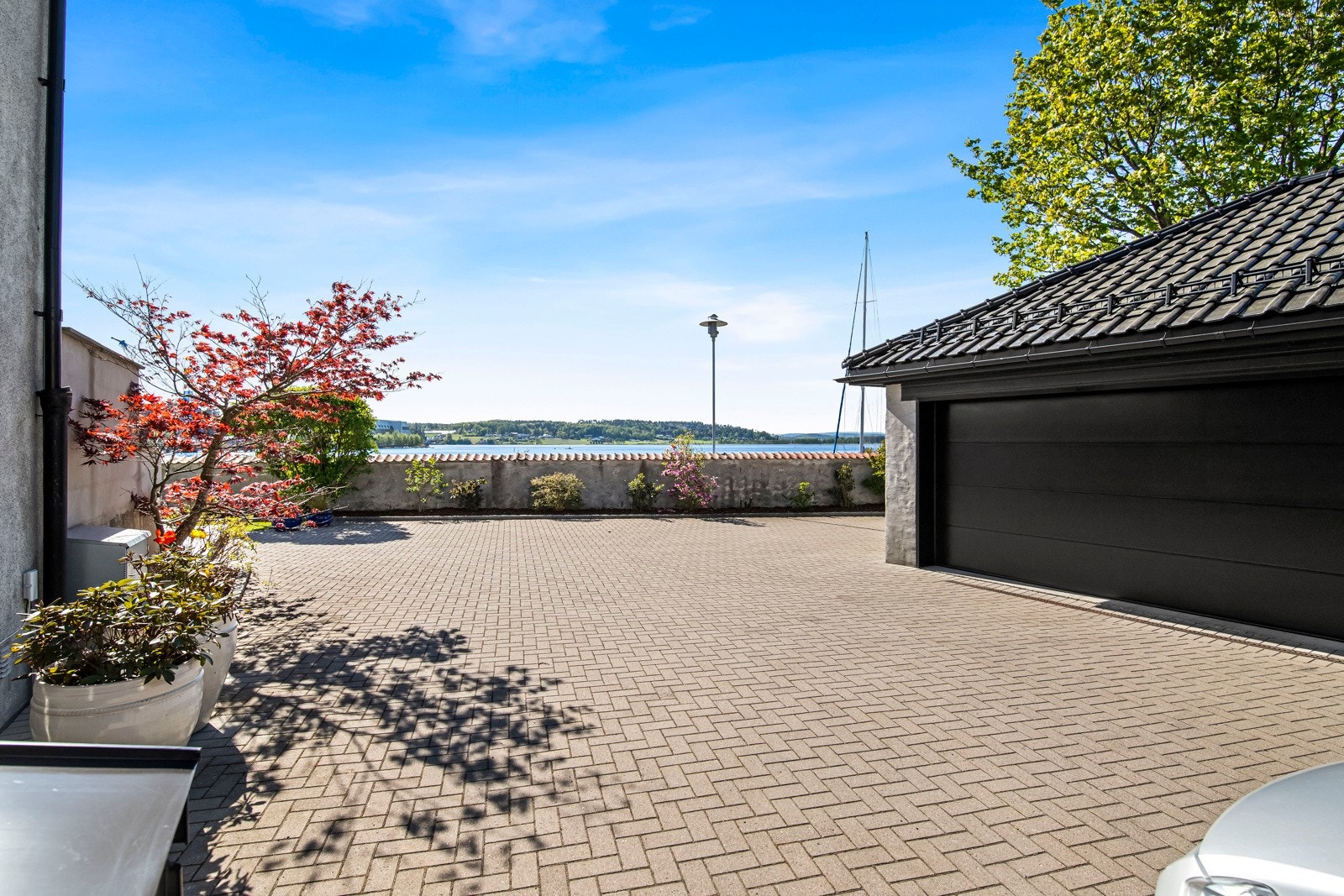 Den store gårdsplassen er steinbelagt, og glir nesten sømløst over til en stor, vestvendt terrasseplatting med flislagt dekke. Galleribilde