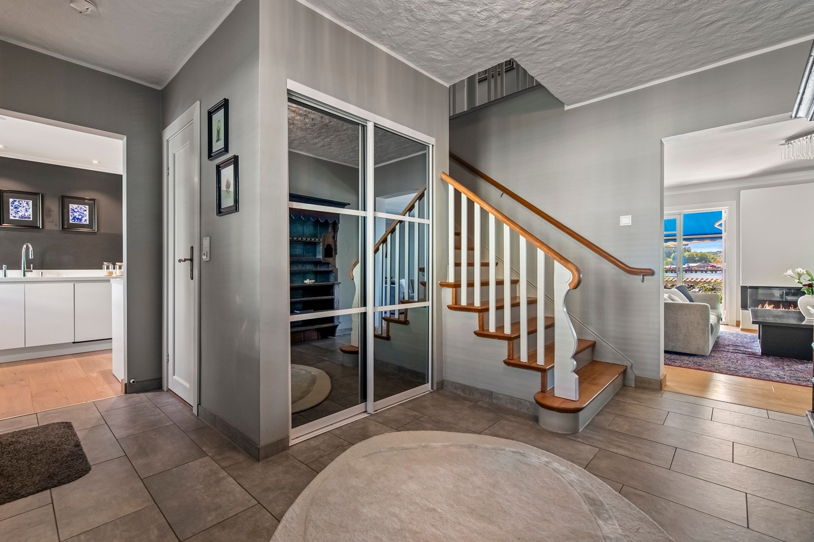 Boligen har et stilfullt, overbygd inngangsparti med asfaltert tilkomst, en elegant skiferlagt trapp og takmontert utebelysning som skaper en innbydende atmosfære. Galleribilde