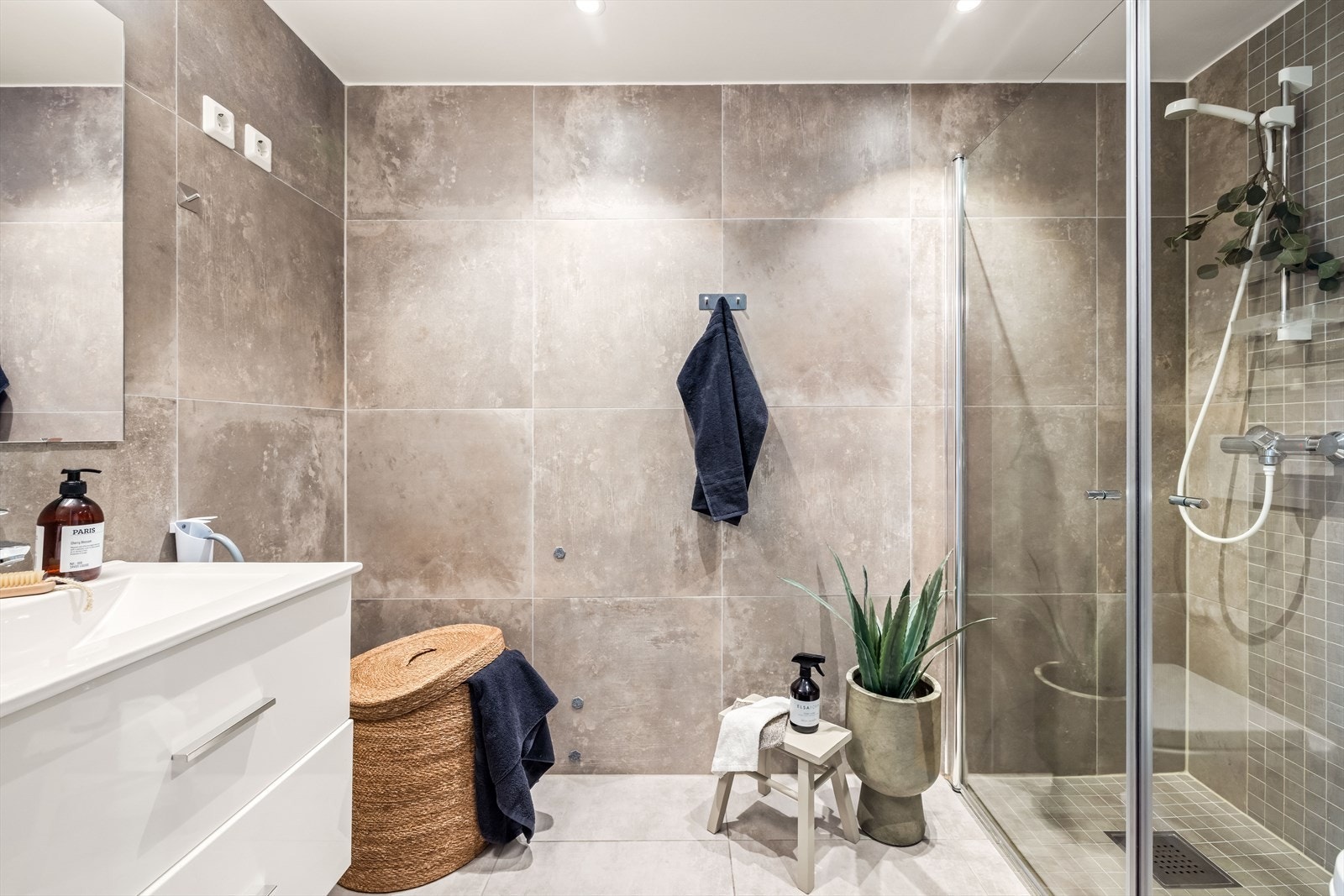 Moderne bad med mørke gulvfliser, gulvvarme og downlights i himlingen. Galleribilde