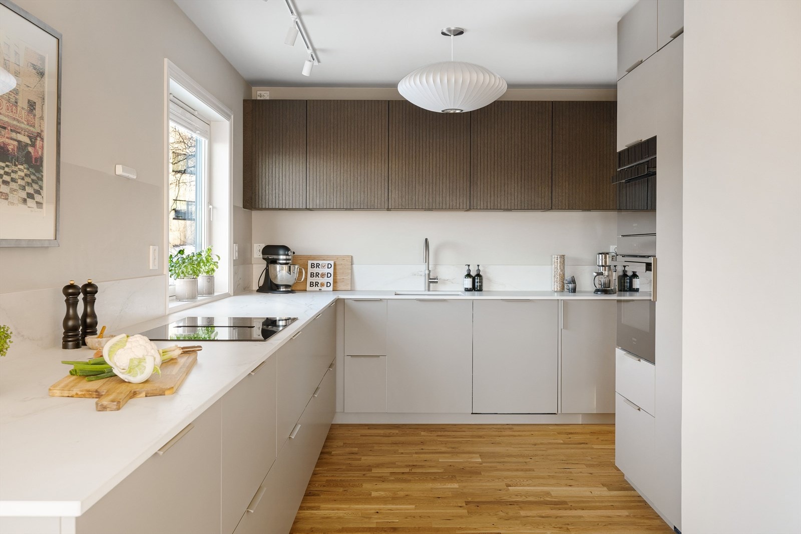 Gjennomtenkt kjøkken i moderne design med rikelig skap- og benkeplass. Galleribilde