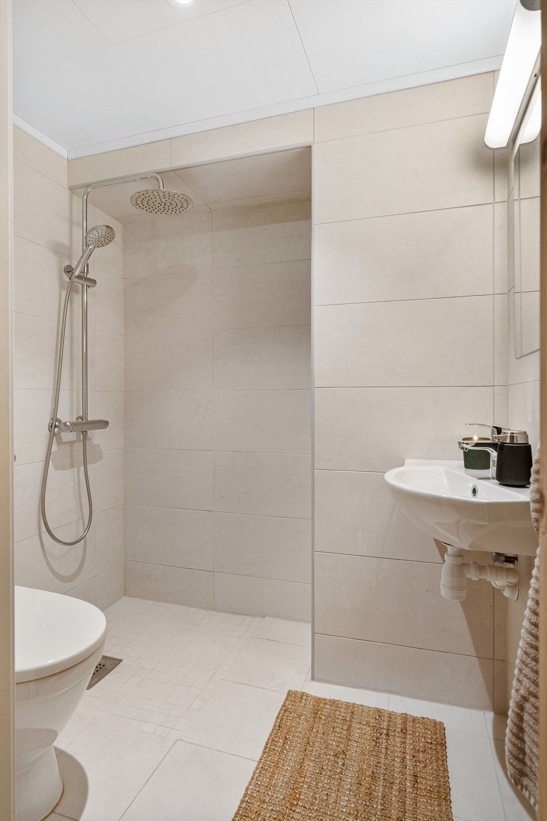 Stilrent og flislagt baderom i praktisk tilknytning til treningsrommet. Galleribilde