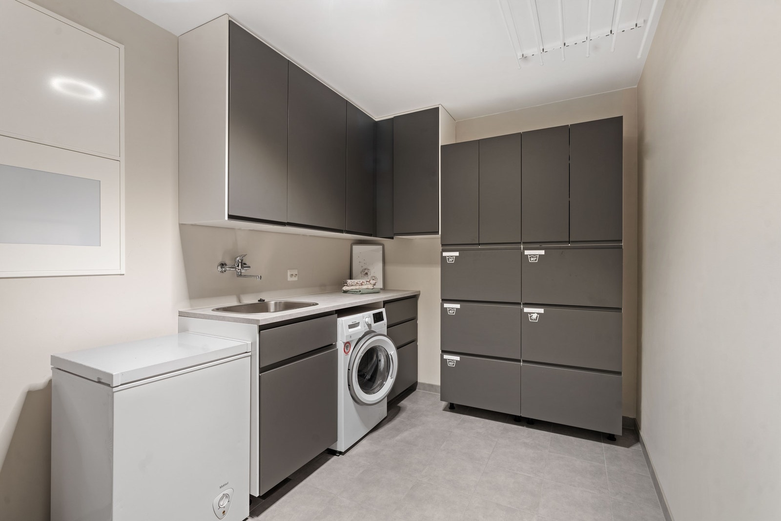 Vaskerom med innredning og takmontert tørkestativ. Galleribilde