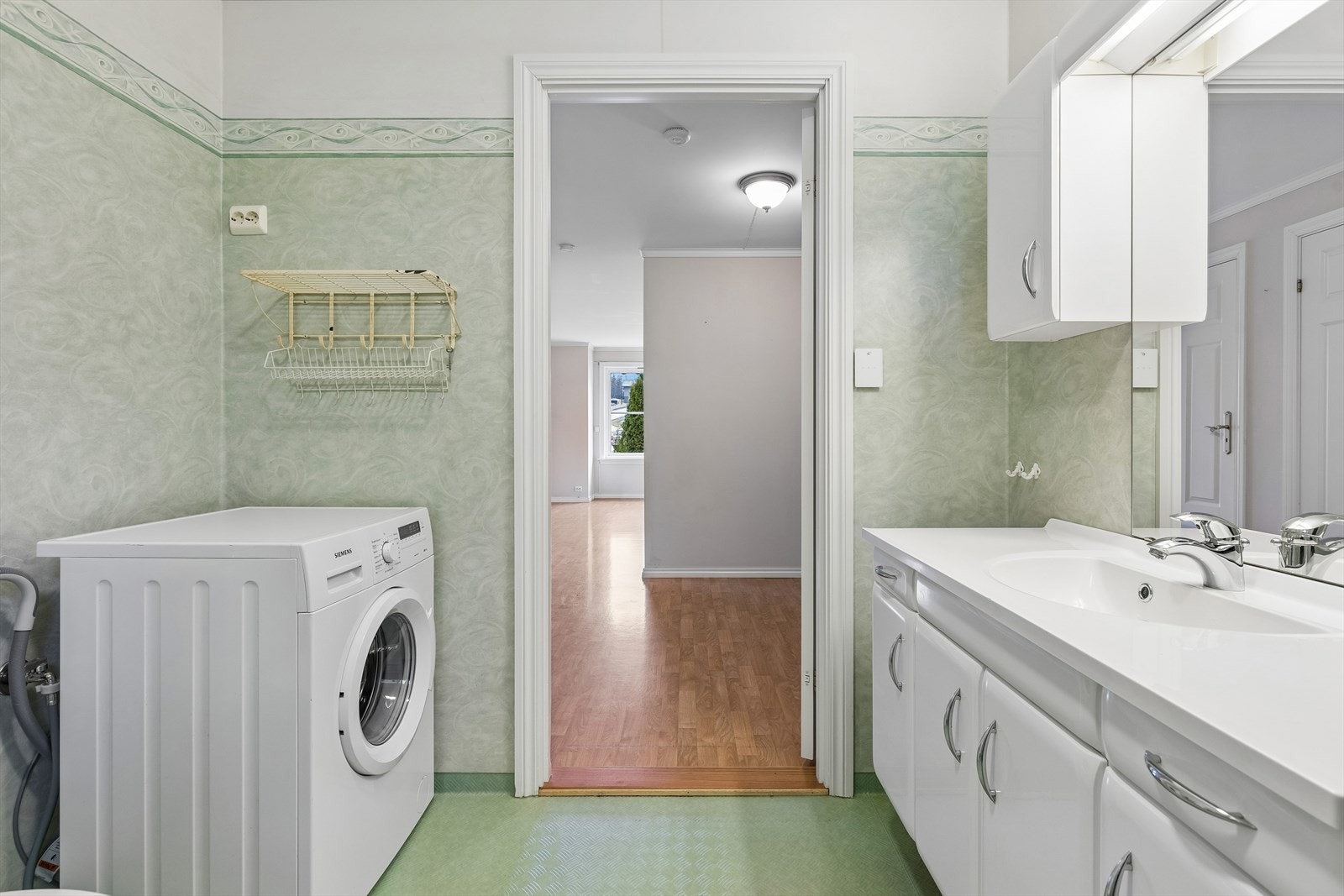 Her er det dusjhjørne med glassdører og praktisk opplegg for vaskemaskin. Galleribilde