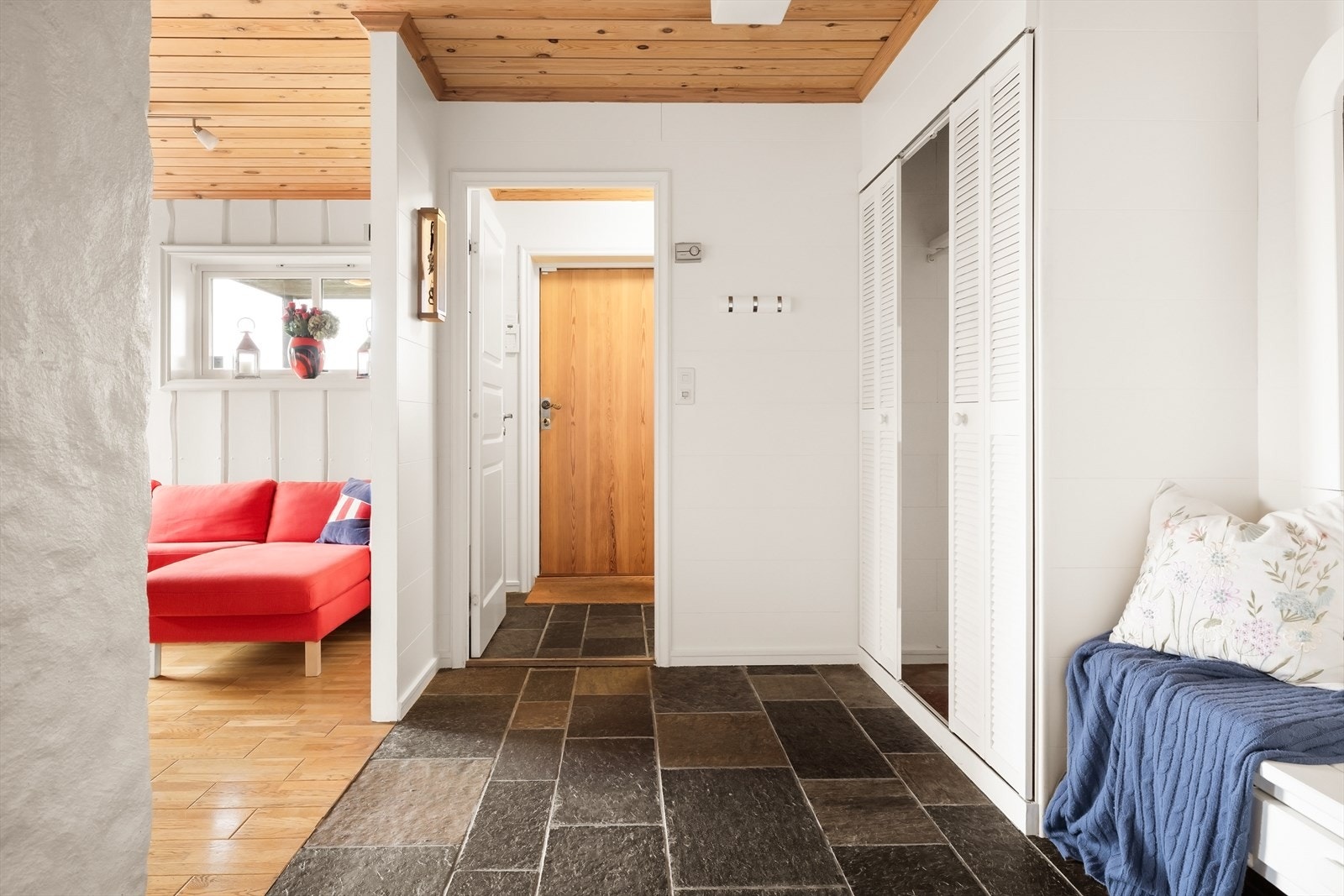 Inngangspartiet fremstår lyst og innbydende, med skifergulv og en praktisk garderobeløsning som gir godt med plass til yttertøy og sko. Galleribilde