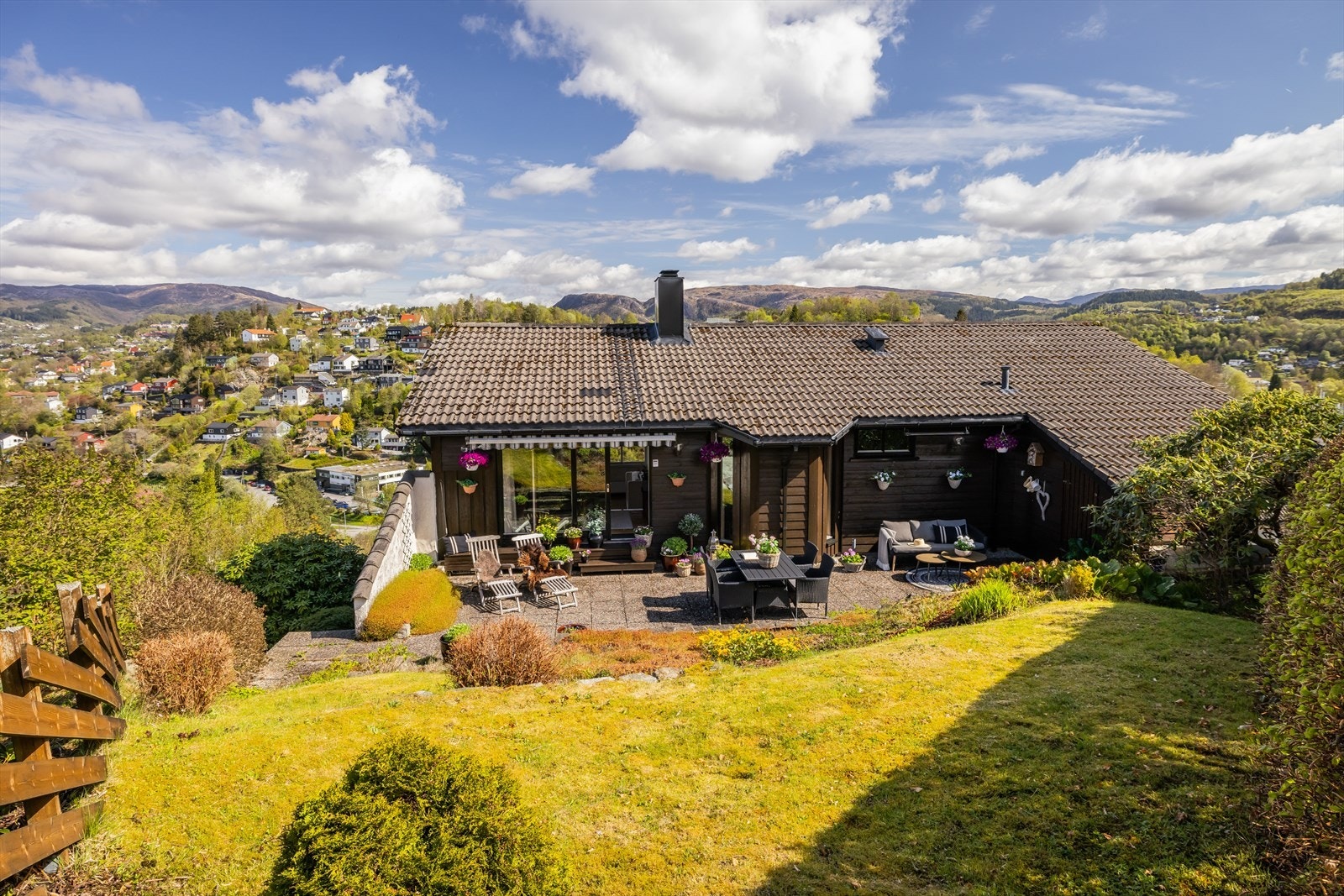 Ute venter en frodig, pent opparbeidet hage med lune kroker, solrike terrasser og god plass til både hverdag og helg. Galleribilde